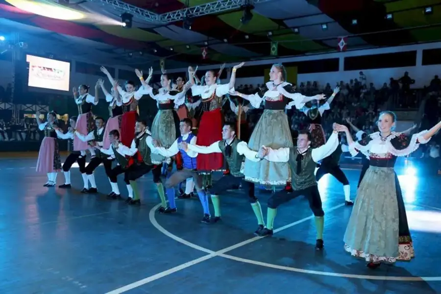Grupo de danças alemãs em trajes típicos se apresentando no palco
